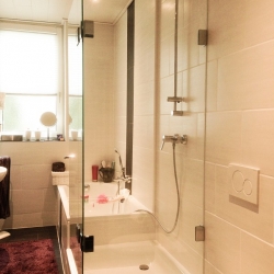 Glasdusche neben Badewanne