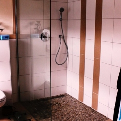 Glasdusche offen auf Mosaikfliesen